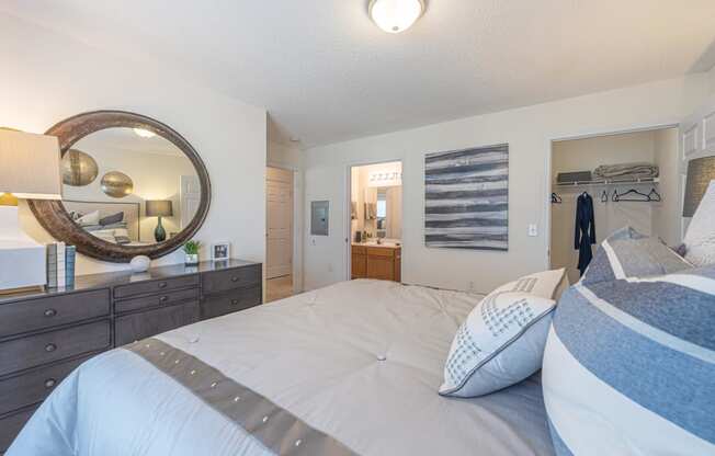 a bedroom with a bed and a mirror and a closet