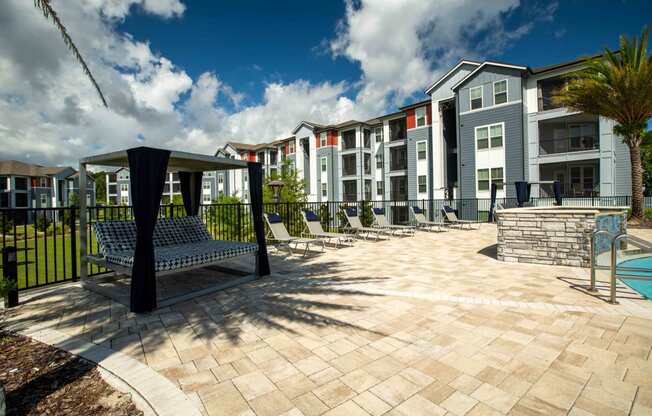 a courtyard with benches and a pool in front of an apartment building