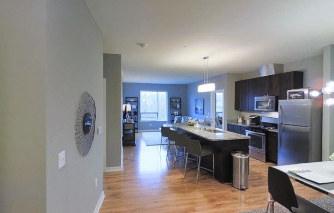 a kitchen and dining room with stainless steel appliances and wood flooring
