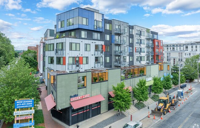 A multi-story building with a green awning and a sign at 603 Concord Apartments, Cambridge, Massachusetts