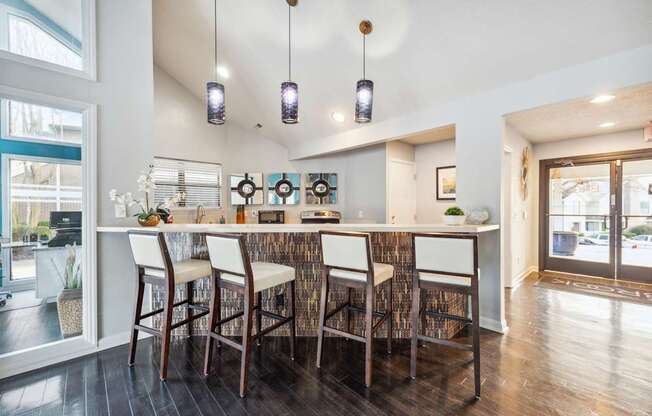 A kitchen with a bar area and chairs.