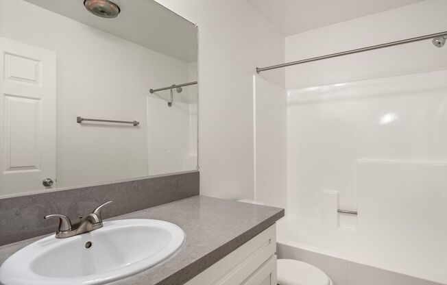 A white sink with a silver faucet in a bathroom.