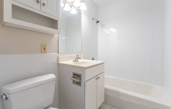 bathroom with bright vanity and white tiling