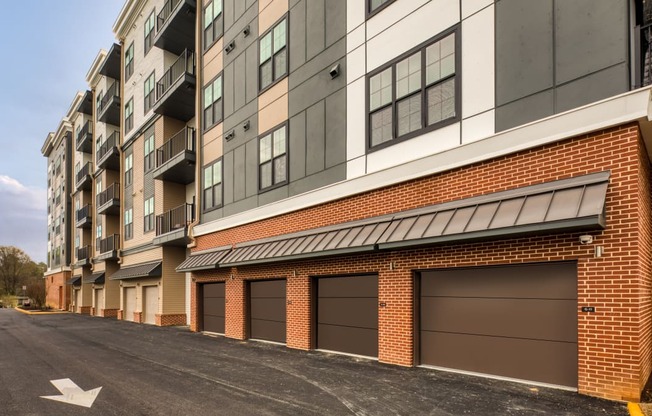 a brick building with brown garage doors on a street at Aura Stonebridge, Virginia