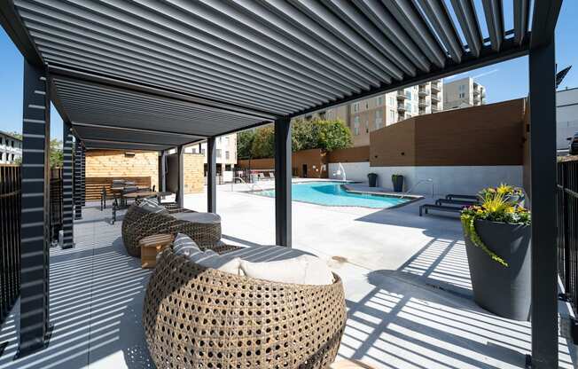 A patio with a pool and sun loungers.