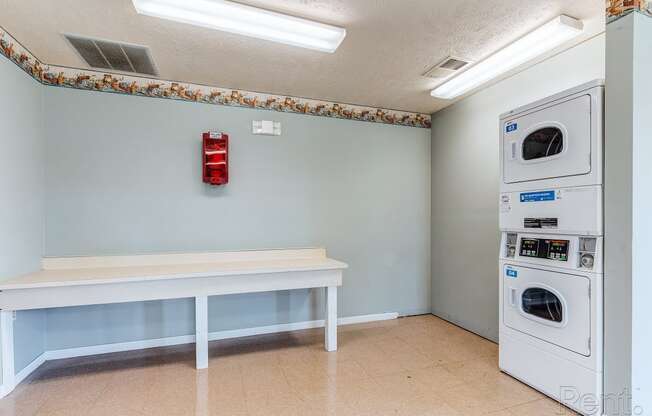 a laundry room with a table and washer and dryer