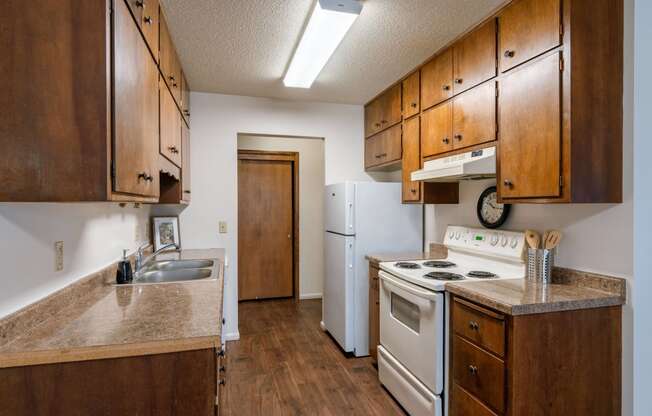 a kitchen with white appliances and wooden cabinets. Fargo, ND Betty Ann Apartments