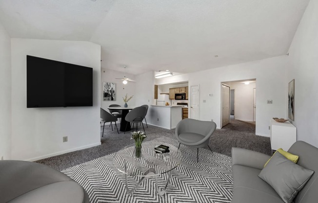 the living room and dining room of an apartment with a couch and chairs