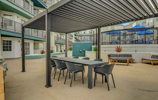A patio with a table and chairs under a roof.