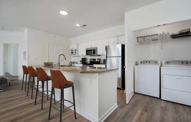 A kitchen with white appliances and brown bar stools.