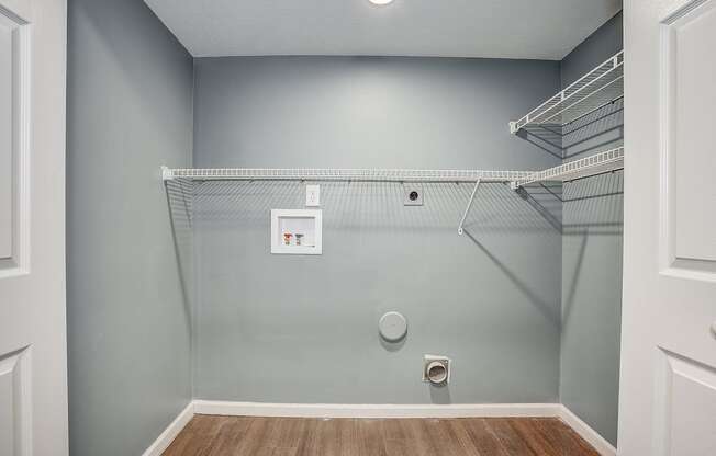 A walk-in closet with a white door and shelves.
