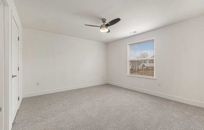 an empty bedroom with a ceiling fan and a window  at Signature Pointe Apartment Homes, Athens, 35611