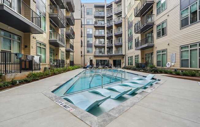 A swimming pool in front of apartment buildings.