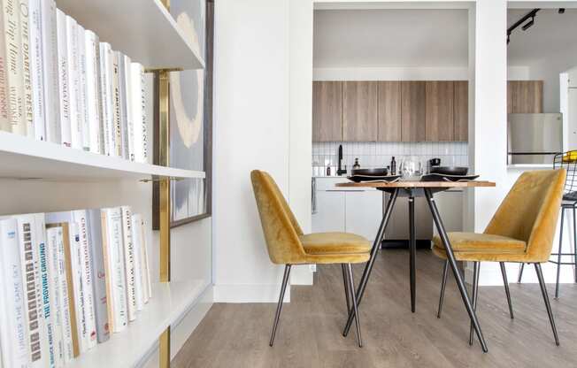 a dining room with a table and chairs and a book shelf