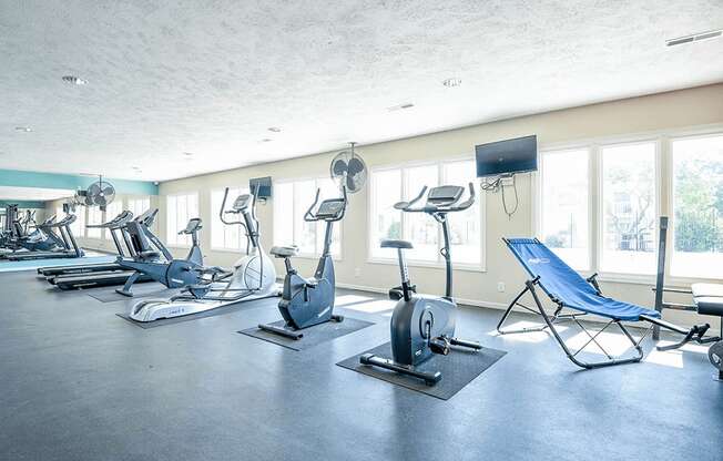 a gym with plenty of exercise equipment and windows