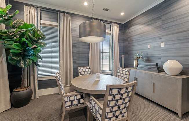 A dining room with a round table and chairs.