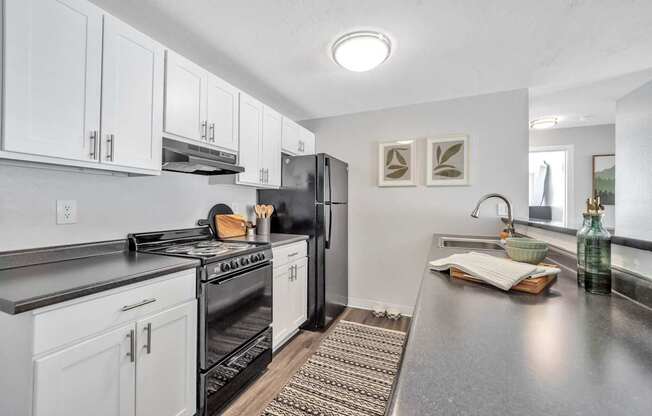 A modern kitchen with white cabinets and stainless steel appliances.