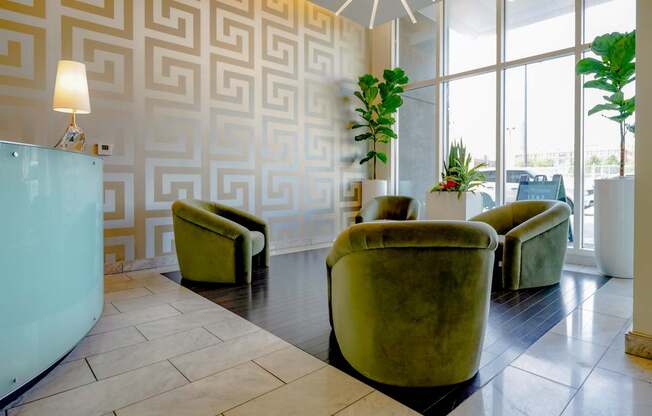A waiting area with green chairs and a white wall with a pattern.