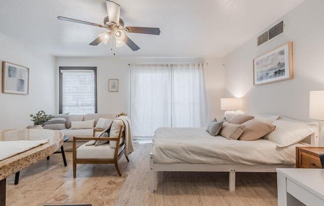 a bedroom with two beds and a ceiling fan