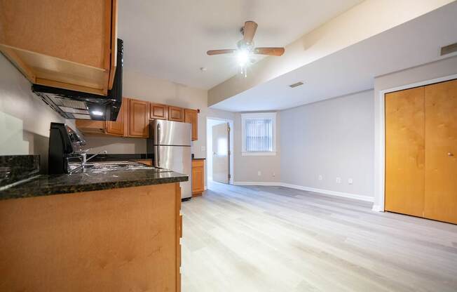 A kitchen with wooden cabinets and a black countertop.