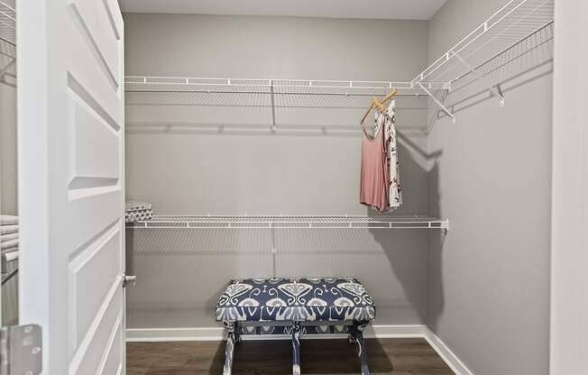 a walk in closet with a and a rack with clothes
