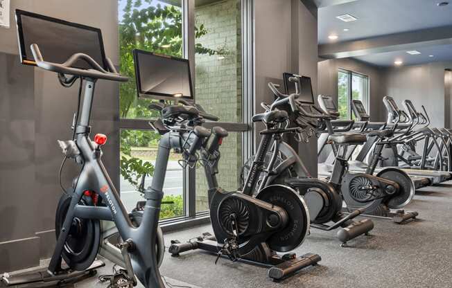 A gym with a row of stationary bikes.
