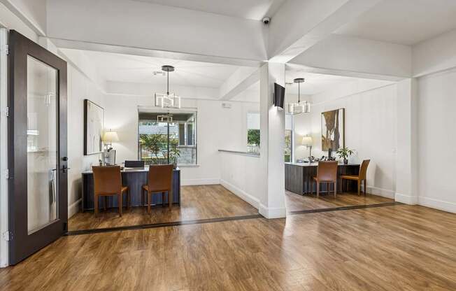 A room with a wooden floor and a dining table with chairs.
