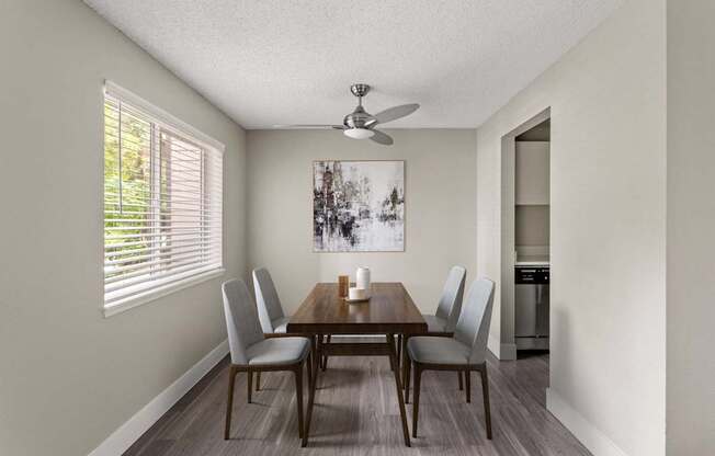 A dining room with a wooden table and chairs.