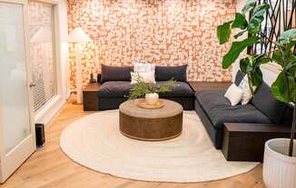 A living room with a grey couch and a wooden coffee table.