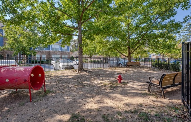 A red fire hydrant sits in the middle of a dirt field.