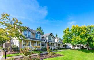 a row of houses with lawns and trees