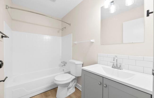 A white toilet sits next to a white sink in a bathroom.