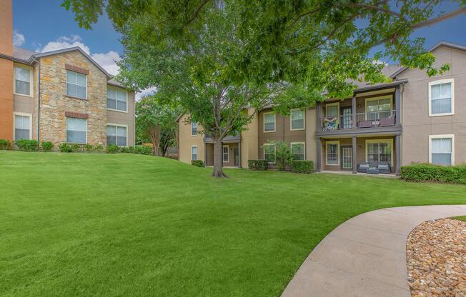 a large brick building with grass in front of a house