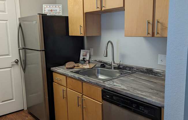 an empty kitchen with stainless steel appliances and wooden cabinets