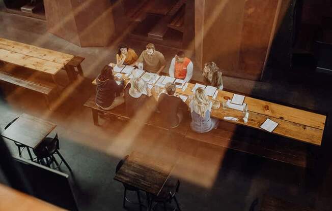 A group of people are sitting around a table in a dimly lit room.