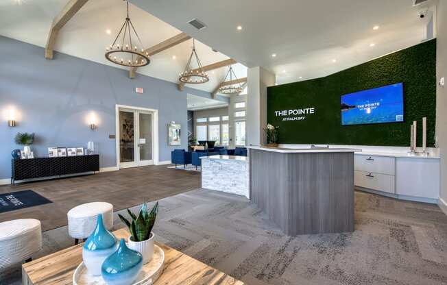 a large lobby with a reception desk and a green wall