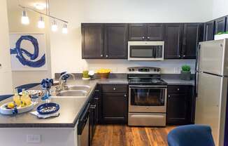 A kitchen with dark brown cabinets and stainless steel appliances.