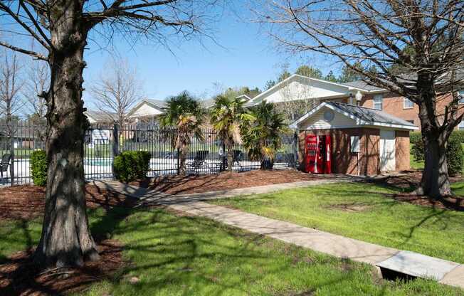A tree in a yard with a house in the background.