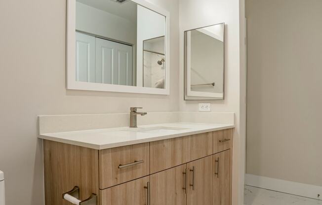 a bathroom with a wooden vanity with a mirror and a toilet