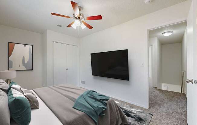 A living room with a grey couch and a black television.