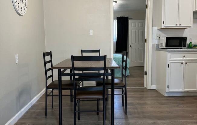 a kitchen and dining room with a table and chairs and a clock on the wall