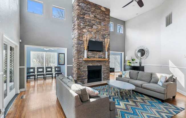 the living room has a large stone fireplace and couches