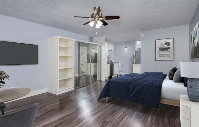 A bedroom with a bed, a chair, and a ceiling fan.