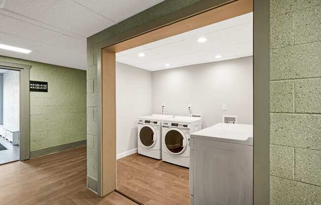 a washer and dryer in a laundry room with a counter and a door