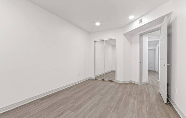 a renovated living room with white walls and wood flooring