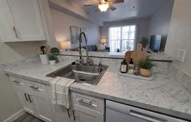 A kitchen with a marble countertop and stainless steel appliances.