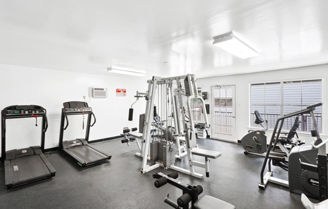the view of a fitness room with cardio equipment