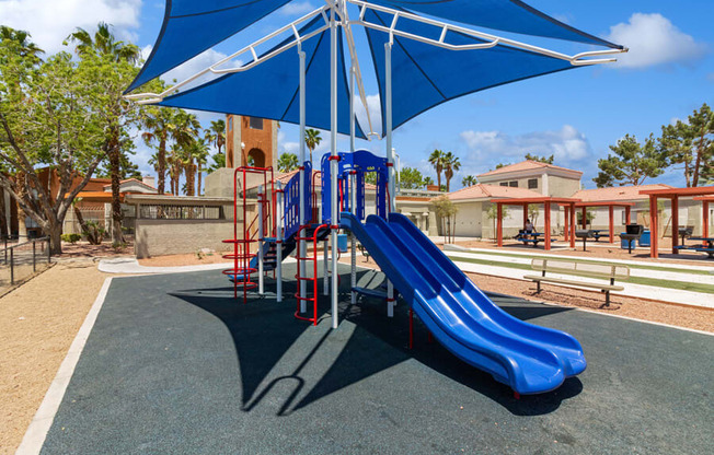 a playground with a blue slide and a red slide