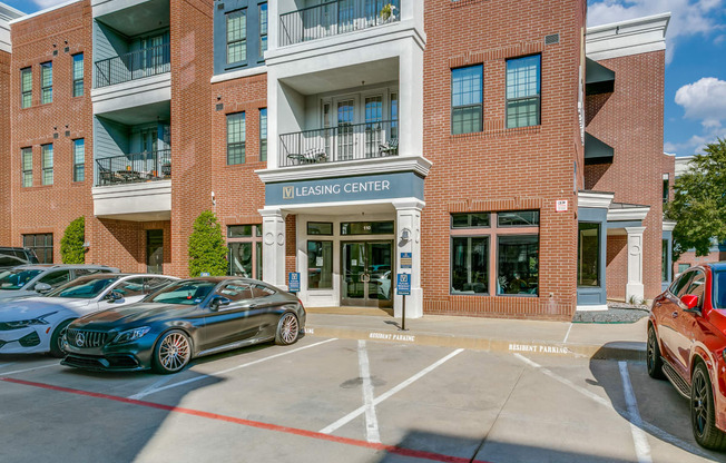 a building with a parking lot and cars parked in front of it