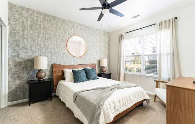 A bedroom with a bed, nightstands, and a ceiling fan.